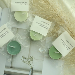 Set of four green scented tealight candles in a cozy lifestyle scene with dried flowers