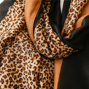 Close-up of leopard print scarf with gold foil accents and soft color-block panels