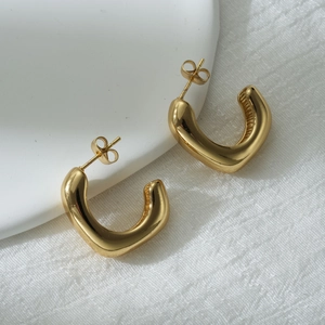 Polished 18k gold-plated stainless steel geometric C-shaped hoop earrings on white silk