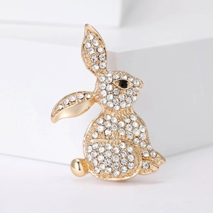 Macro shot of a gold-plated rabbit brooch featuring sparkling clear rhinestones