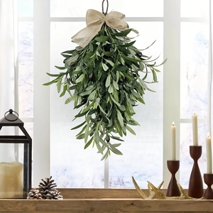 Artificial olive leaf door swag with burlap bow hanging on a rustic window frame