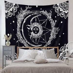 Detail of bohemian black and white tapestry with sun and moon pattern in a bedroom setting