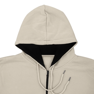 Détail d'un sweat à capuche beige en polaire avec doublure noire contrastée de la capuche