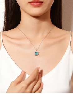 Detail of S925 silver necklace featuring a square Paraiba gemstone pendant on model