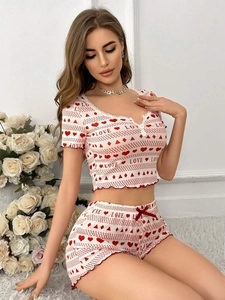 Detail of white rib-knit pajama set featuring red heart prints and delicate lace trim