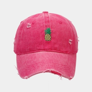Detail of distressed rose red washed cotton baseball cap with pineapple embroidery