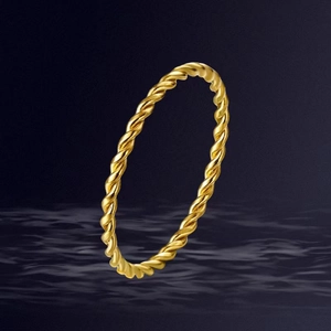 Detailed view of a gold-toned twisted rope ring over a deep blue rippled water background