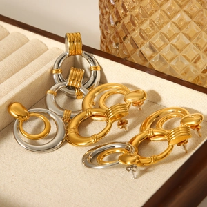 Macro view of layered gold and silver mixed metal hoop earrings in a jewelry box