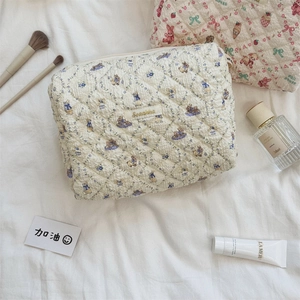 Détail de la trousse matelassée en coton avec motifs de lapins bleus et étiquette