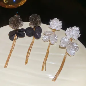 Elegant acrylic flower tassel earrings in black and pearl white with gold chain drops
