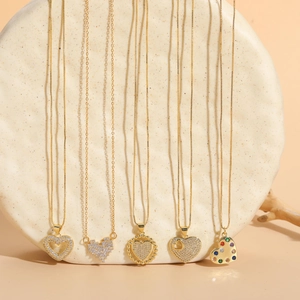 Detail of five gold heart pendants with cubic zirconia and multicolor gemstones
