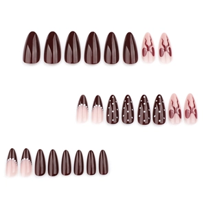 French almond press-on nails in coffee brown with white polka dots and red ribbon bows
