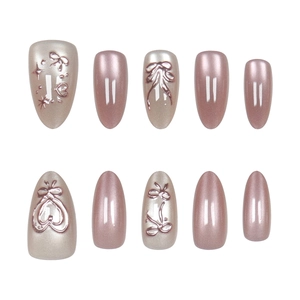 Detailed view of rose gold cat-eye press-on nails with 3D bow and heart relief designs