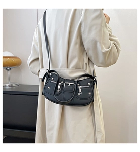 Detail of black leather motorcycle bag with silver rivets and decorative zippers