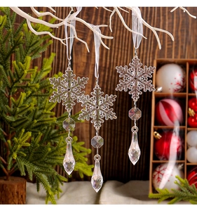 Close-up of clear acrylic snowflake pendants with prism drops on a festive Christmas tree