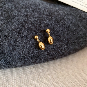 Vue détaillée de boucles d'oreilles goutte en plaqué or 18k sur tissu en maille