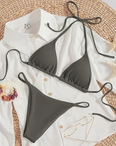 Flat lay of ribbed dark grey halter bikini set on beach accessories and starfish