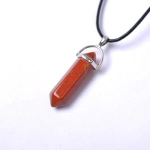 Macro view of red jasper hexagonal crystal point pendant with a silver-tone clasp and cord