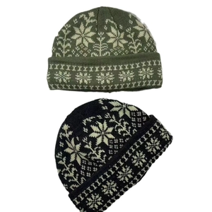 Army green and black knitted beanie hats with white jacquard snowflake patterns