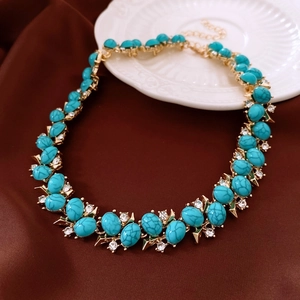 Detail of vintage necklace with turquoise gemstones and clear crystals on gold setting
