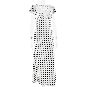 Détail de la robe blanche à pois avec col en dentelle et texture de manches bouffantes