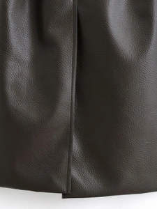 Gros plan sur le cuir marron foncé grainé et les détails de couture sur le manteau