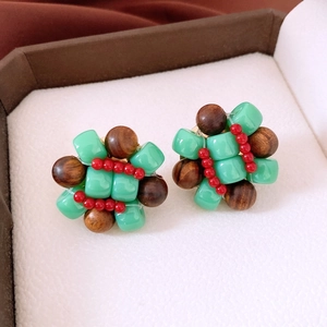 Macro shot of ethnic resin and wood bead cluster earrings in mint green and brown