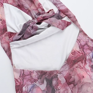Détail du laçage au dos et de l'imprimé marbré violet sur la robe dos nu licou