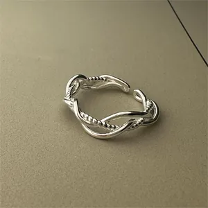 Close-up of twisted rope texture and open-end detail on a silver minimalist ring