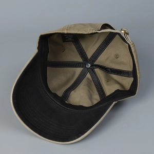 Detail view of khaki cotton baseball cap with adjustable metal buckle and inner stitching