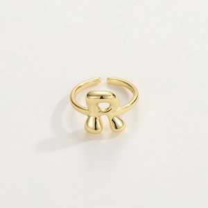 Detail of letter R shaped 18K gold ring with a smooth finish and open adjustable design