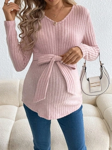Pink V-neck maternity top with long sleeves, ribbed knit texture and waist tie detail
