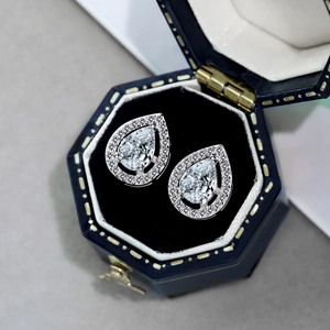 Close-up of pear-cut zircon earrings in a premium blue velvet jewelry gift box