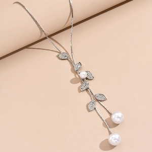 Detail of leaf-shaped pendant with white rhinestones and pearls on silver chain