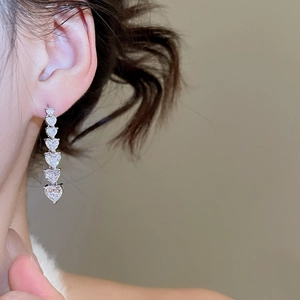 Detail of 18K gold-plated silver needle earrings with gradient heart-shaped zircons
