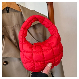 Detailed close-up of red quilted cloud bag with silver zipper and plaid texture