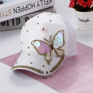 Casquette blanche avec broderie papillon pailletée, strass et détails d'anneaux en métal