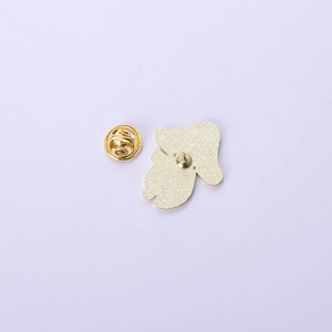 Macro shot of gold butterfly clutch and frosted metal back of a mushroom enamel pin