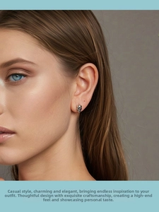 Detail of 925 sterling silver skull earring with red accents on model ear