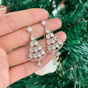 Close-up of silver Christmas tree drop earrings with stars, hearts, and white zircons