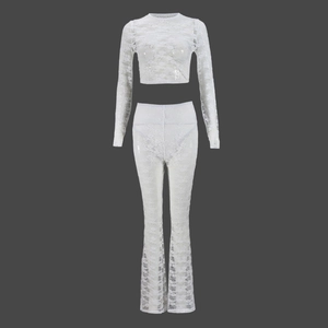 Detail of white floral lace texture on long sleeve crop top and flared pants set