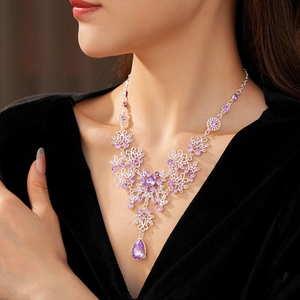 Detail of vintage silver flower pendant necklace with purple crystals on female model