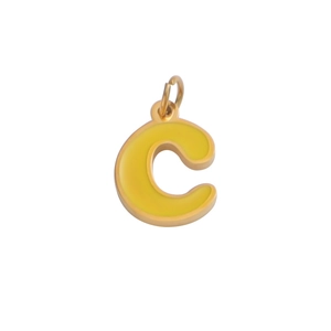 Close-up of a golden metal letter C pendant with yellow enamel inlay and jump ring