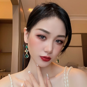 Vintage green teardrop zircon flower earrings with gold finish on model for luxury style