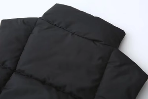Vista dettagliata del collo alto e della trama del tessuto opaco sul gilet nero corto