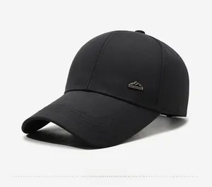 Detail view of a black hard-top baseball cap with a metal mountain badge and twill texture