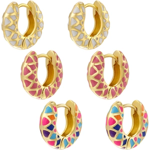 Detail of three colorful enamel hoop earrings with geometric patterns in gold plating
