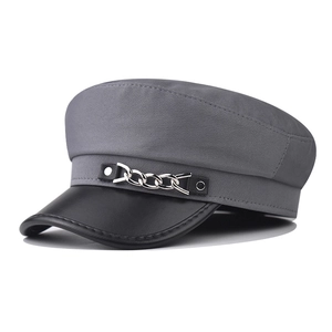 Détail de la casquette grise montrant la chaîne argentée et la visière en cuir noir
