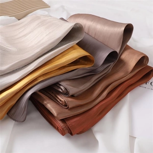 Close-up of glossy silk satin scarves in champagne and gold colors with elegant texture