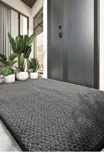 Détail du paillasson gris foncé avec structure à boucles et bordure finement surfilée